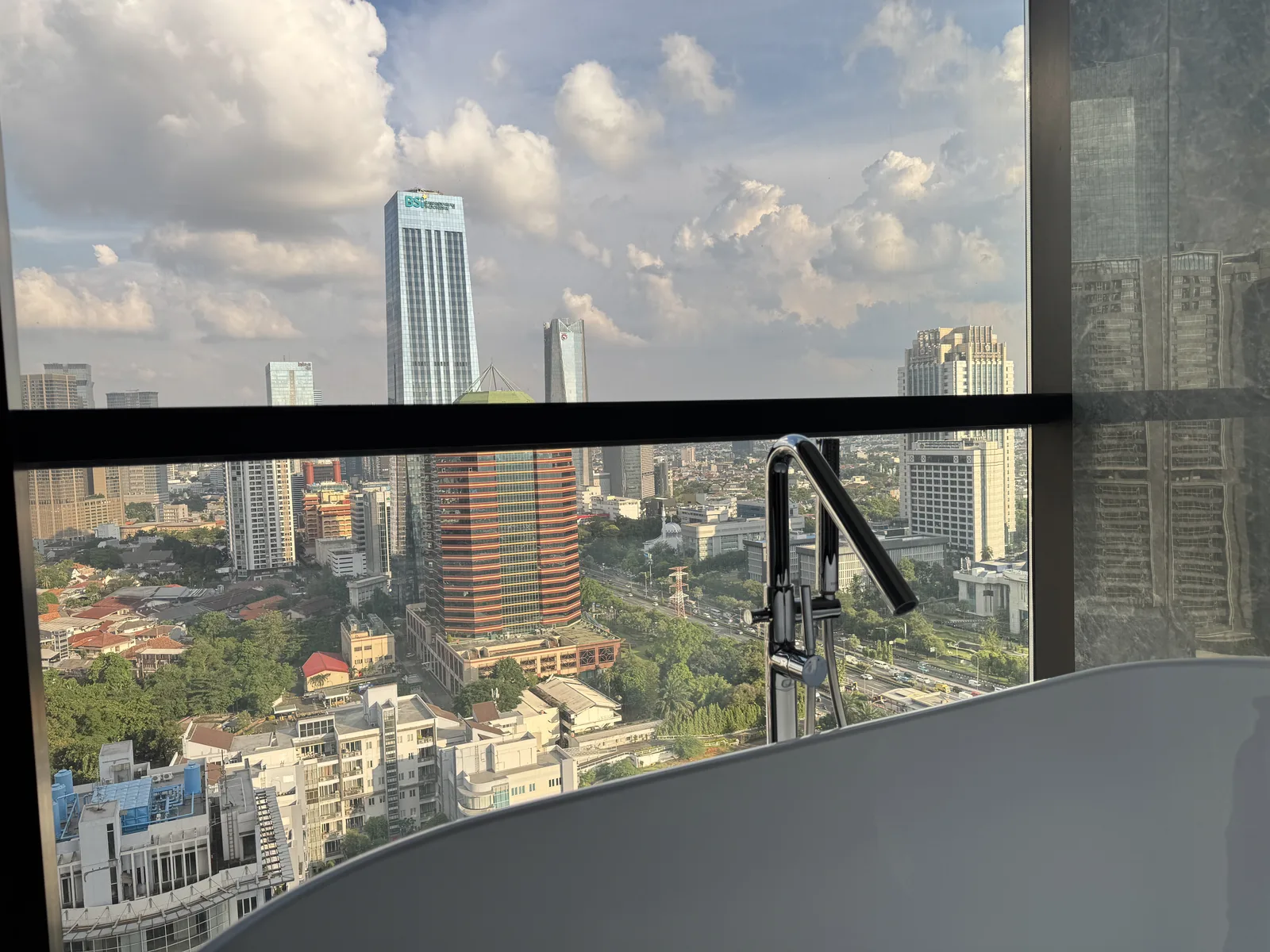 Regent Residences Jakarta bathtub with panoramic Jakarta skyline view